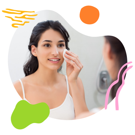 Mujer viéndose al espejo aplicando agua micelar después del maquillaje para limpiar el rostro y así mantener su piel saludable, evitando brotes de acné.